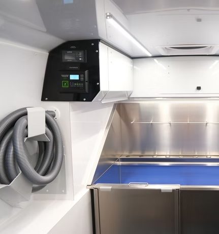 Inside the Coat & Tail grooming van: stainless steel tub and professional dryer