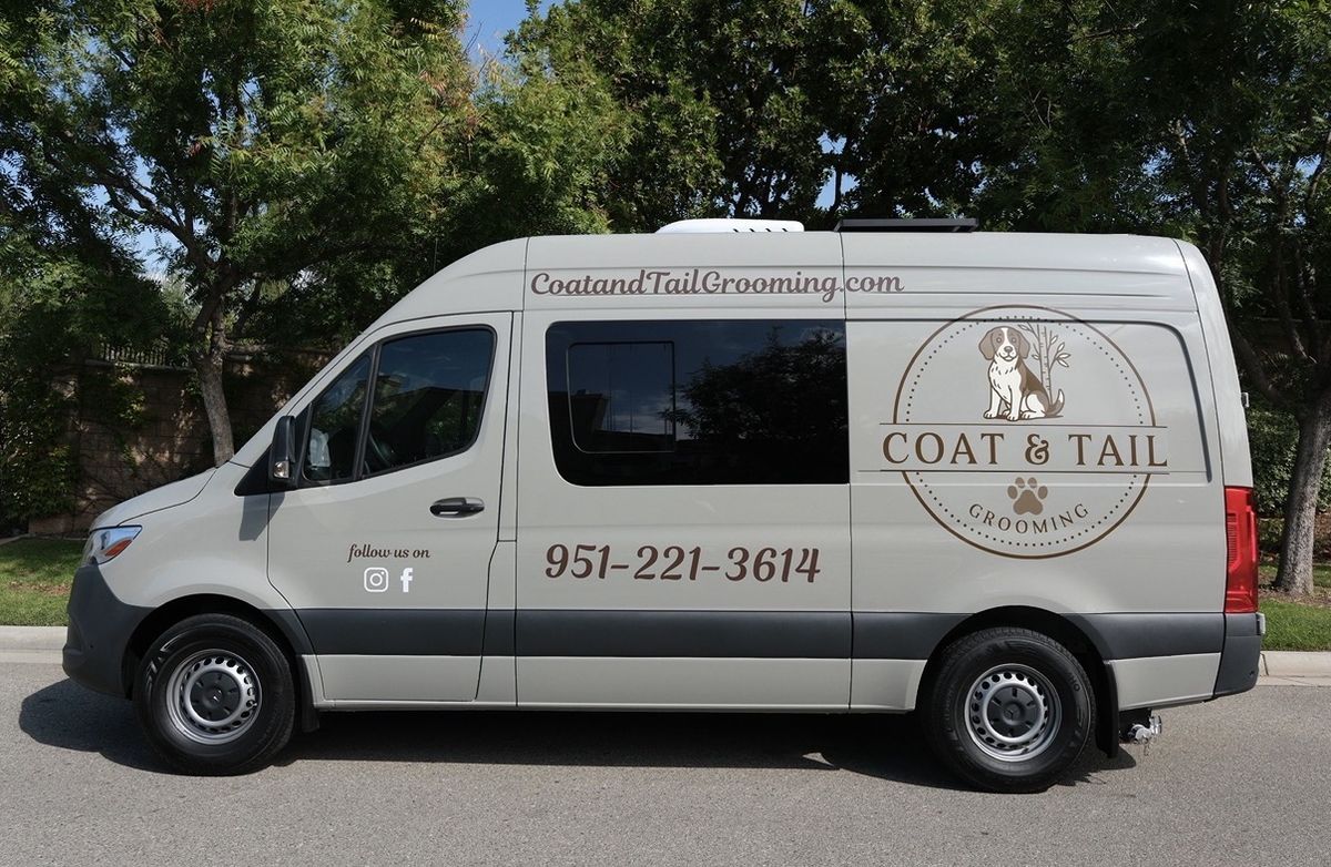 The Coat & Tail Grooming van parked on a tree-lined street